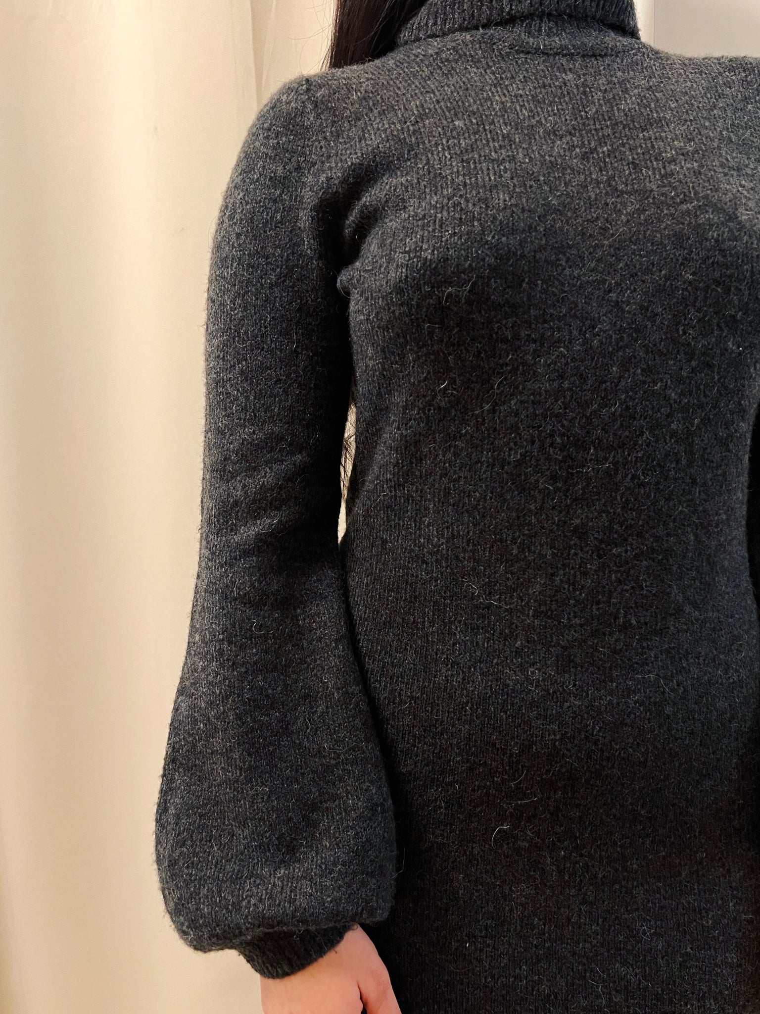 Close up image of woman wearing a turtleneck dress showing the composition of the dress